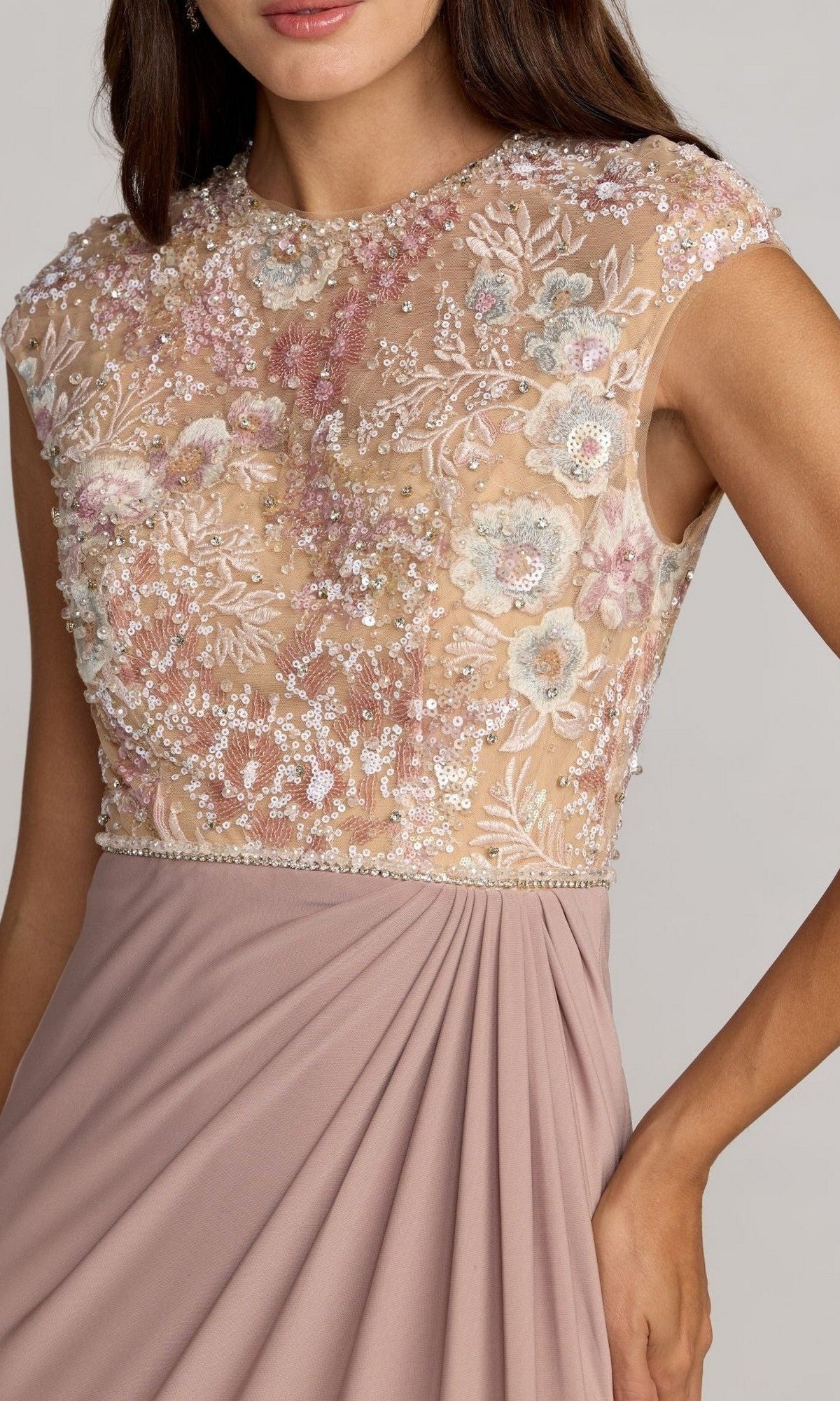 A woman wears the Mac Duggal 21324 long formal dress, featuring a sleeveless mauve design with a sheer, embroidered bodice and a pleated skirt.
